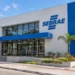 Edifício do Sebrae com fachada branca e azul, rampa e jardim ao lado em dia ensolarado, simbolizando as vagas de estágio do Sebrae.
