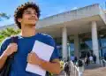 Estudante com mochila e documentos em frente a uma universidade, representando a oportunidade de financiamento pelas vagas remanescentes do Fies 2026.