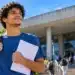 Estudante com mochila e documentos em frente a uma universidade, representando a oportunidade de financiamento pelas vagas remanescentes do Fies 2026.